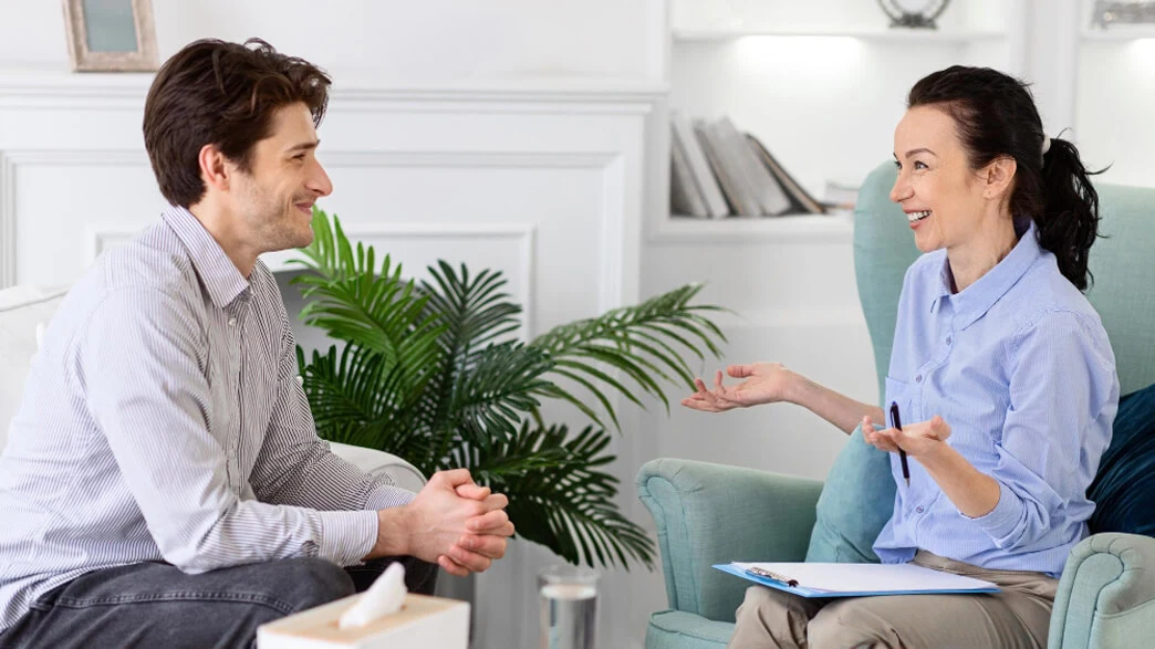 Therapist and patient having a positive conversation during an aftercare support session for addiction recovery